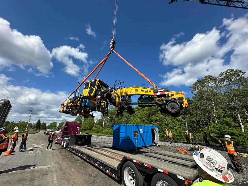 Lifting a rail car tracker repair machine onto the tracks near Falls Creek, PA